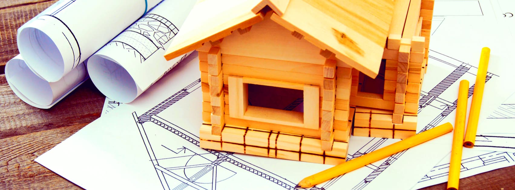 wooden model of house on drawing plans