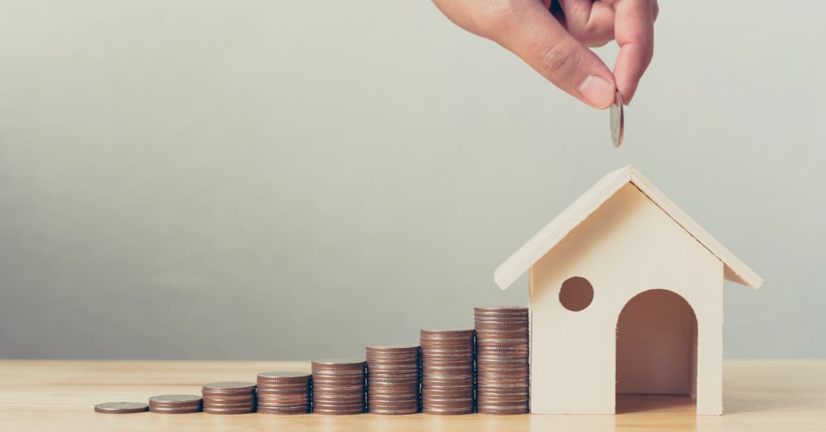 stack of coins rising up to a house