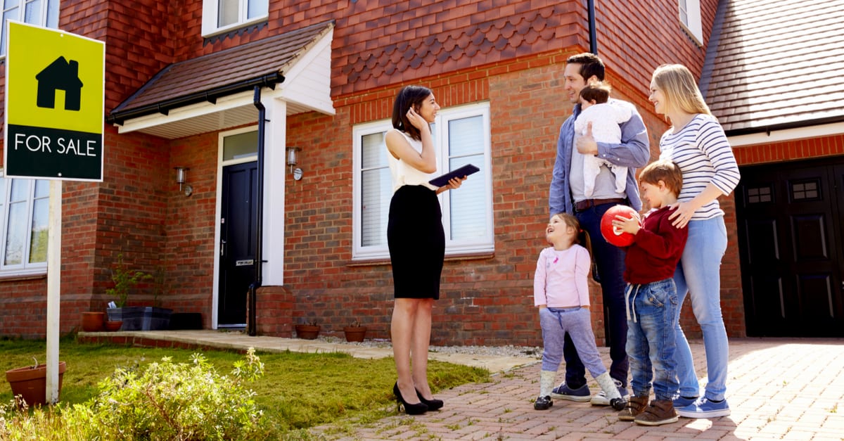 Family outside a property with estate agent